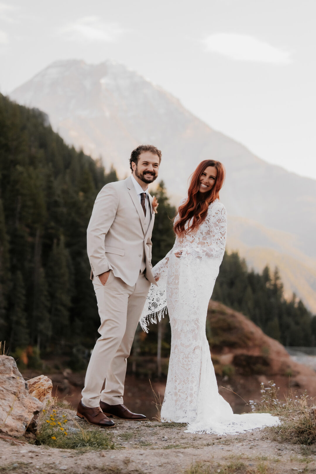 bride and groom smile at photographer during first look