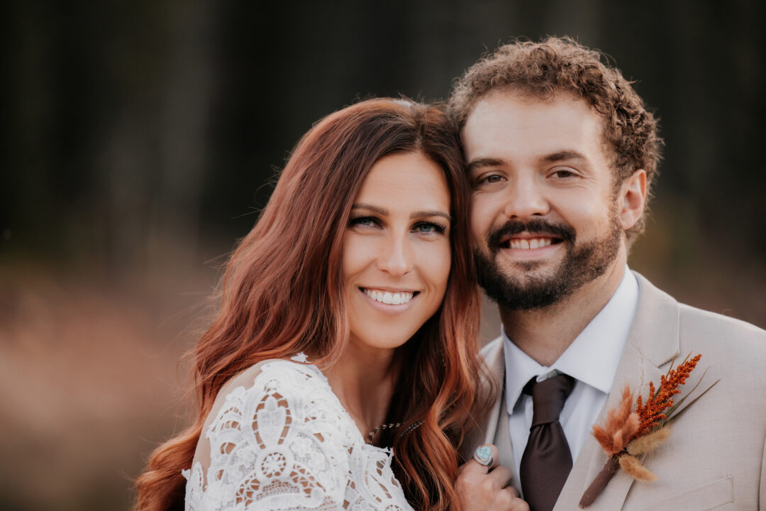 close up of bride and groom smiling at camera