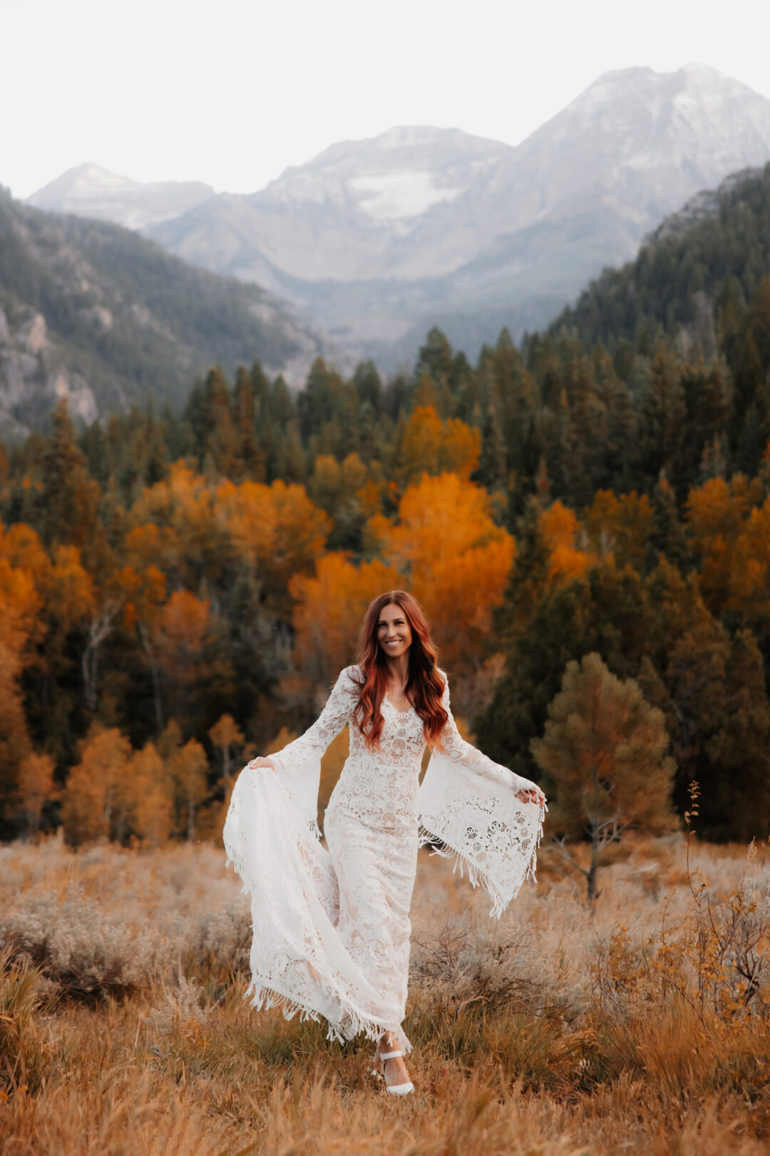 Bride smiling in a field with mountains in Utah