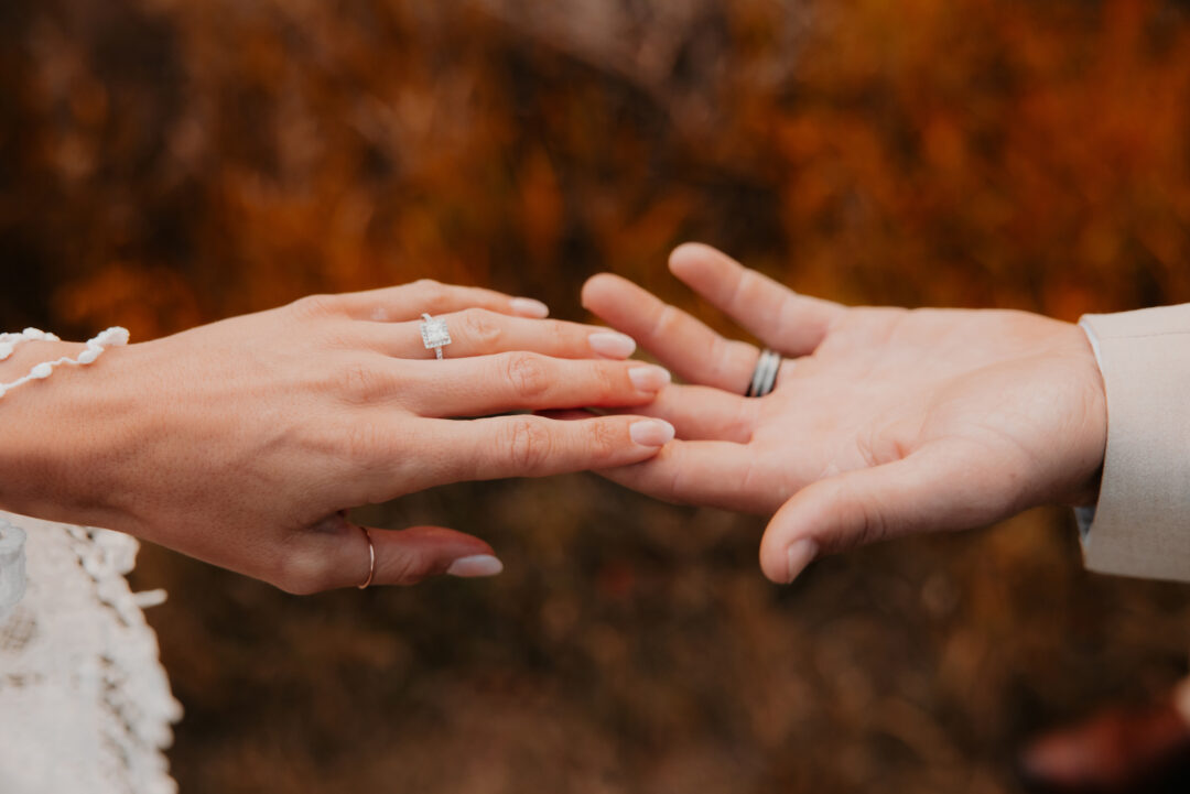 Bride and groom touching hands showing their wedding rights