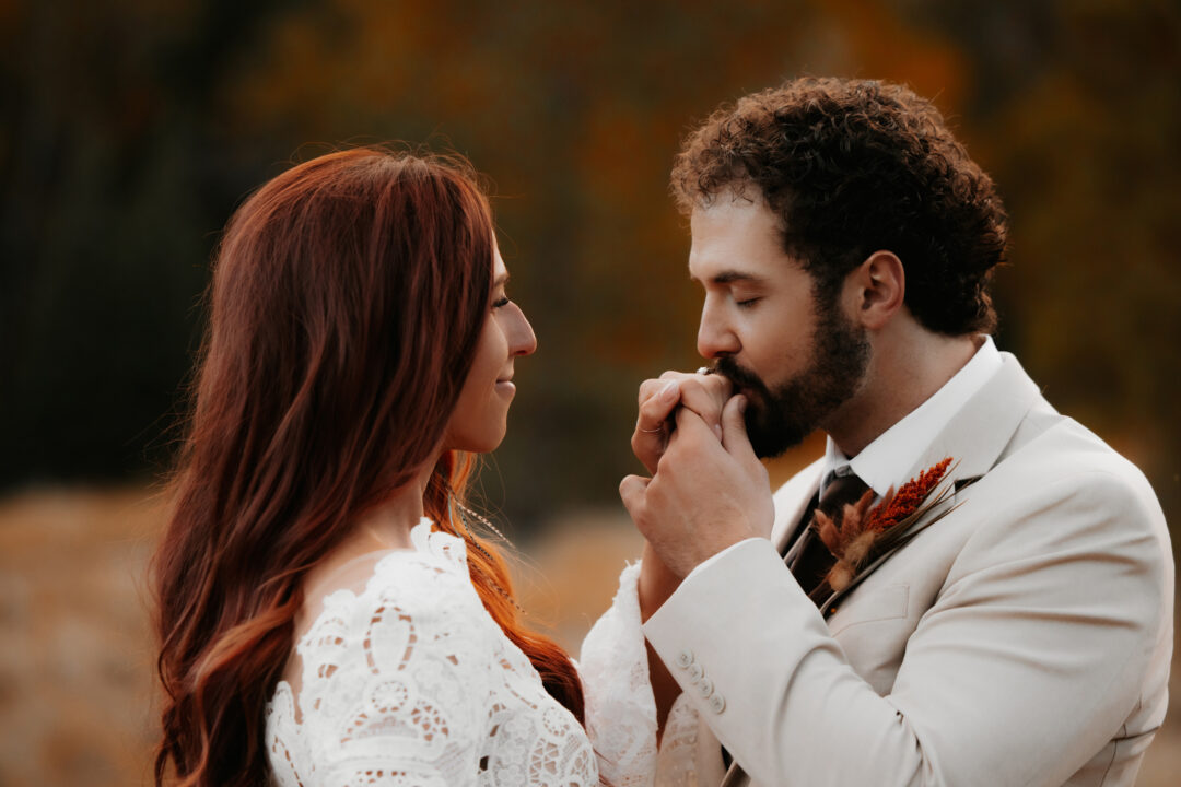 Groom kissing bride&#039;s hand at tibble fork reservoir