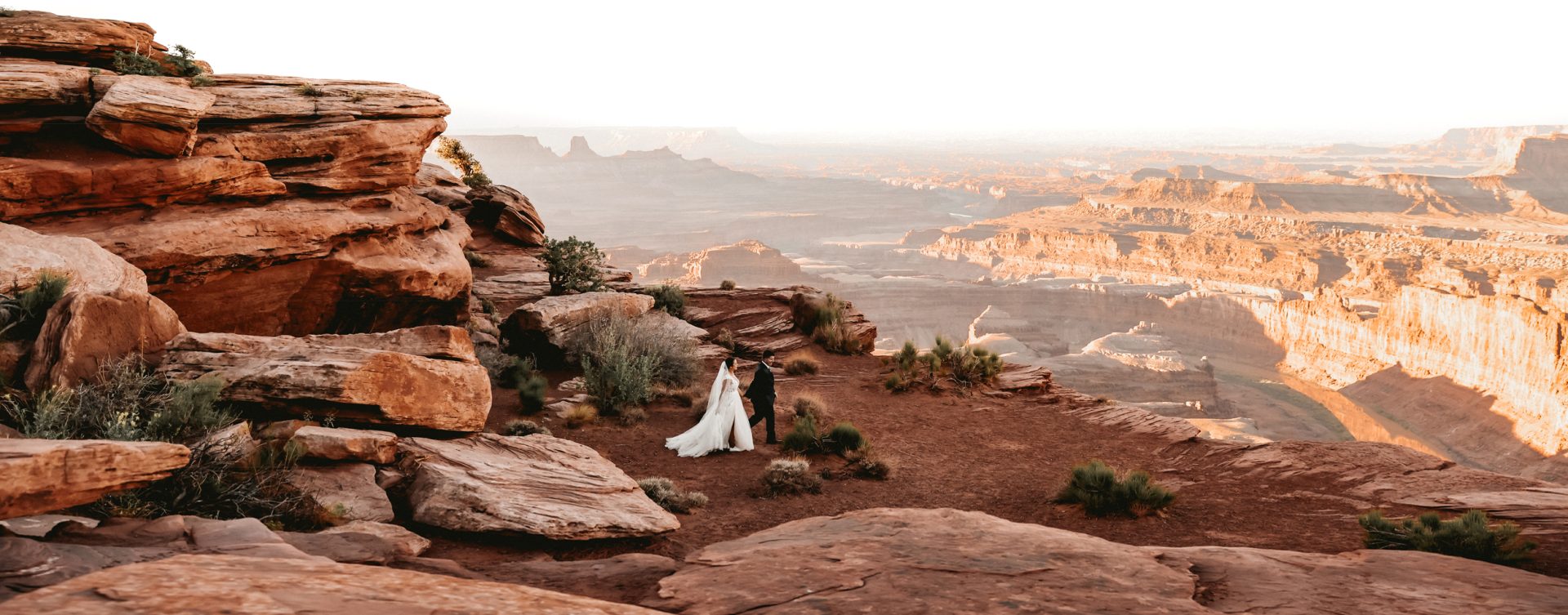 An epic elopement photography image of a bride and groom at dead horse point near Moab utah at sunrise