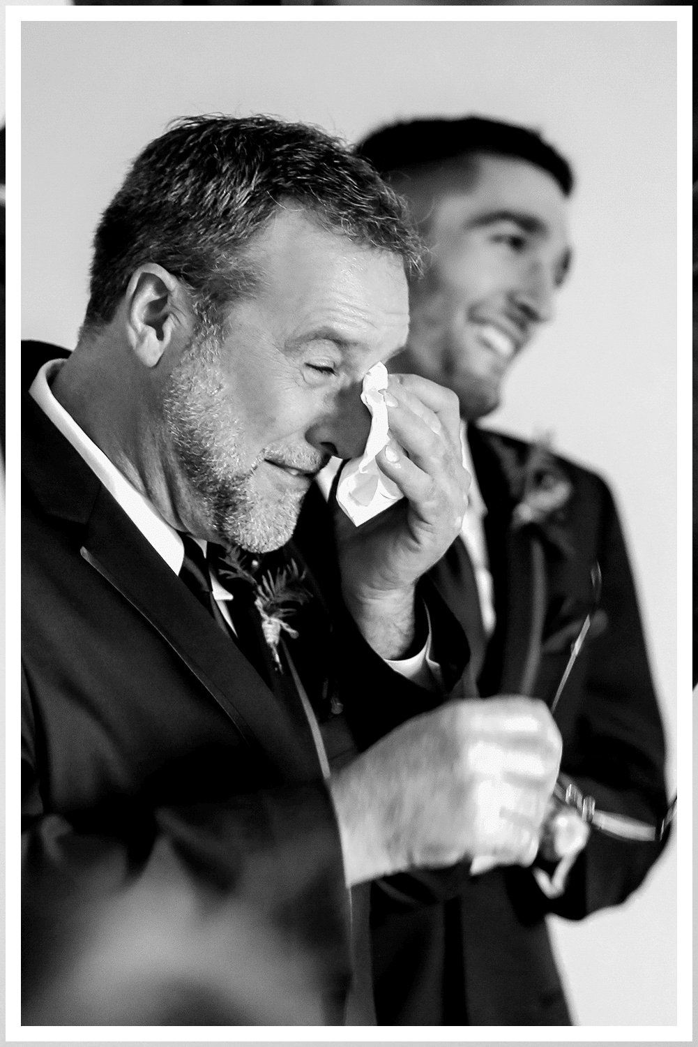A wedding couple in Dead Horse State Park standing on a large stack of deep red stone at sunset with cinematic hazy lighting near the edge of the cliff.
