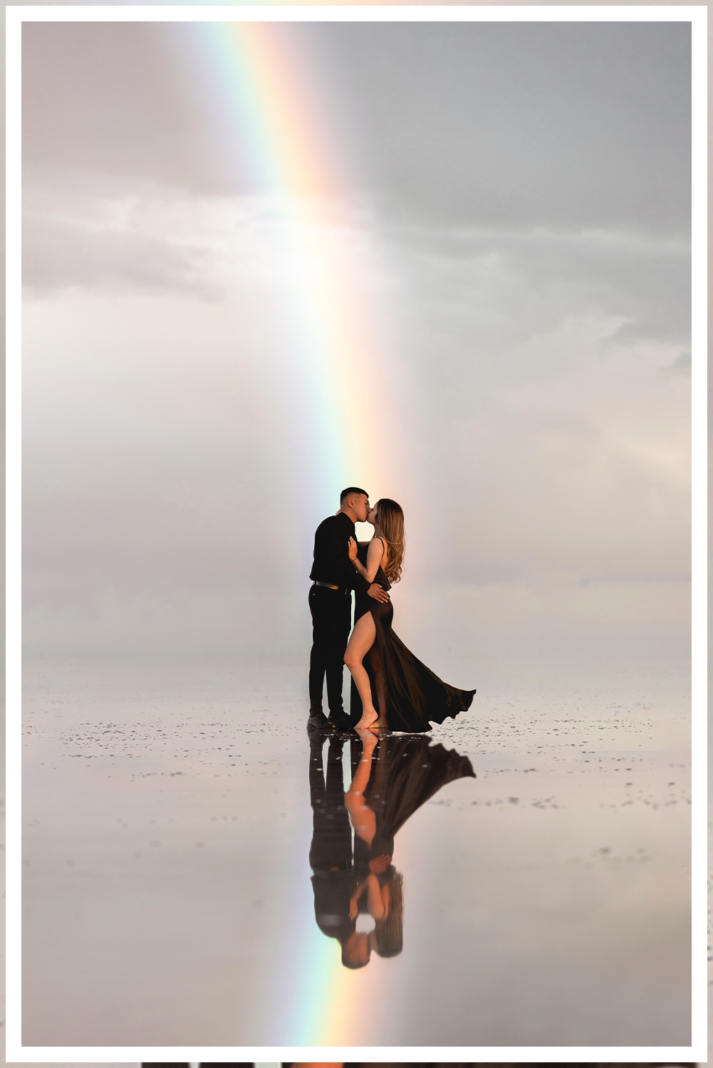 A bride and groom in ornate Indian clothing with a vast desert landscape with stormy skies and lighting with dreamy sunset lighting.