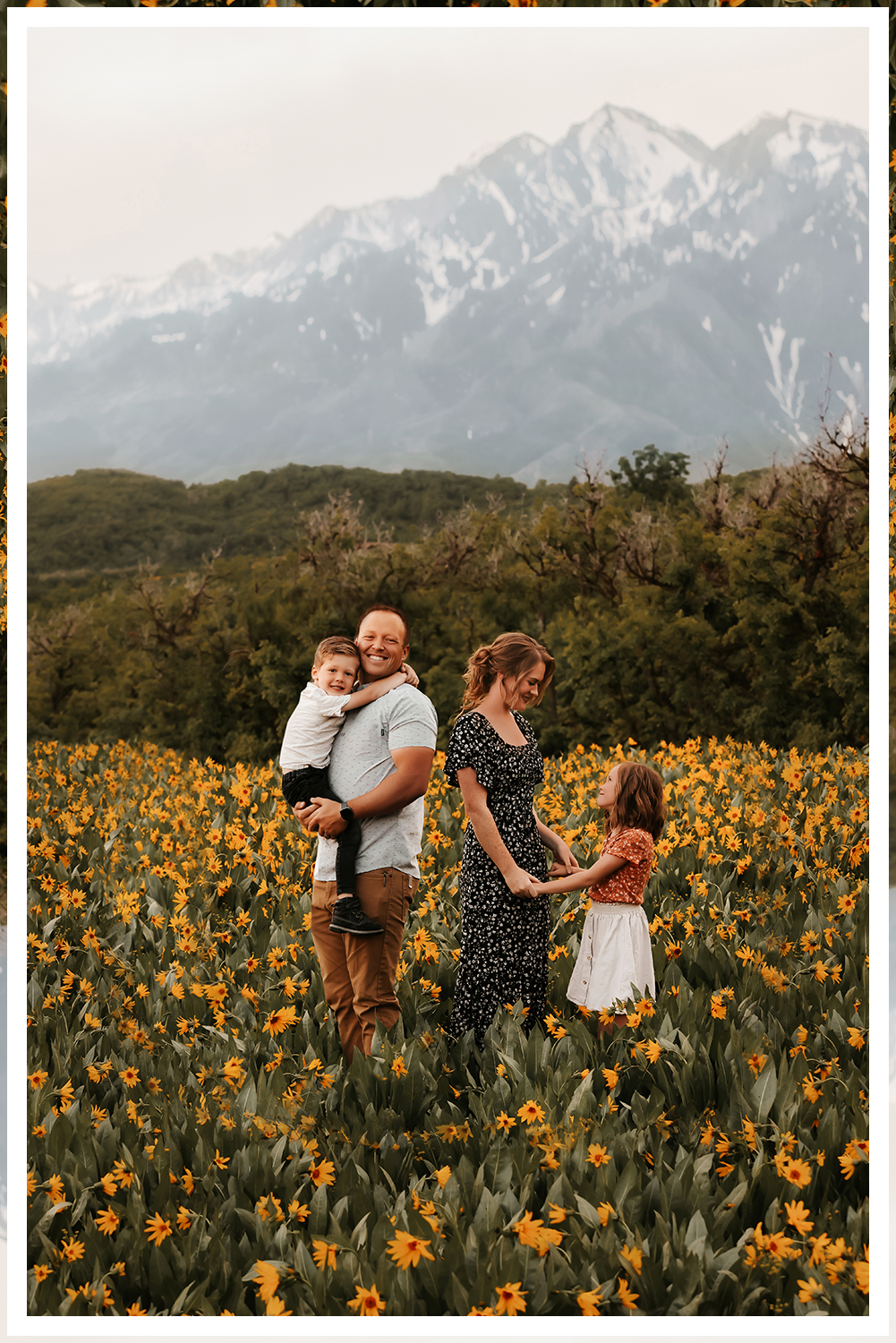 A wedding couple in Dead Horse State Park standing on a large stack of deep red stone at sunset with cinematic hazy lighting near the edge of the cliff.